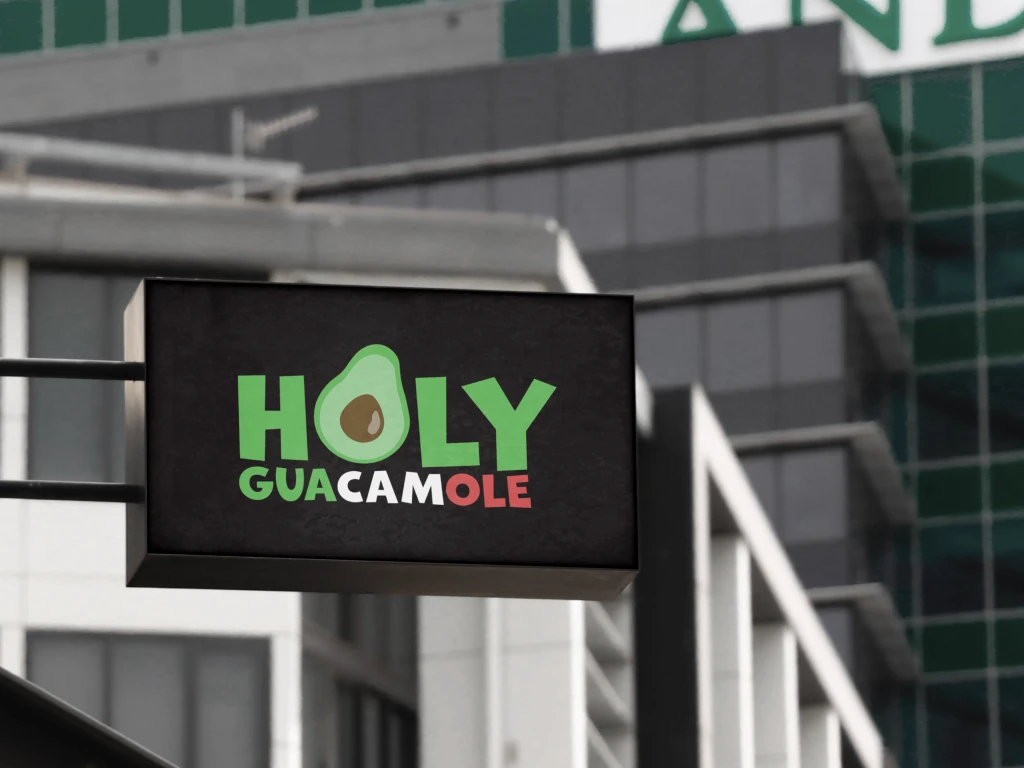 A black street sign presenting a Holy Guacamole logo on a dark background.