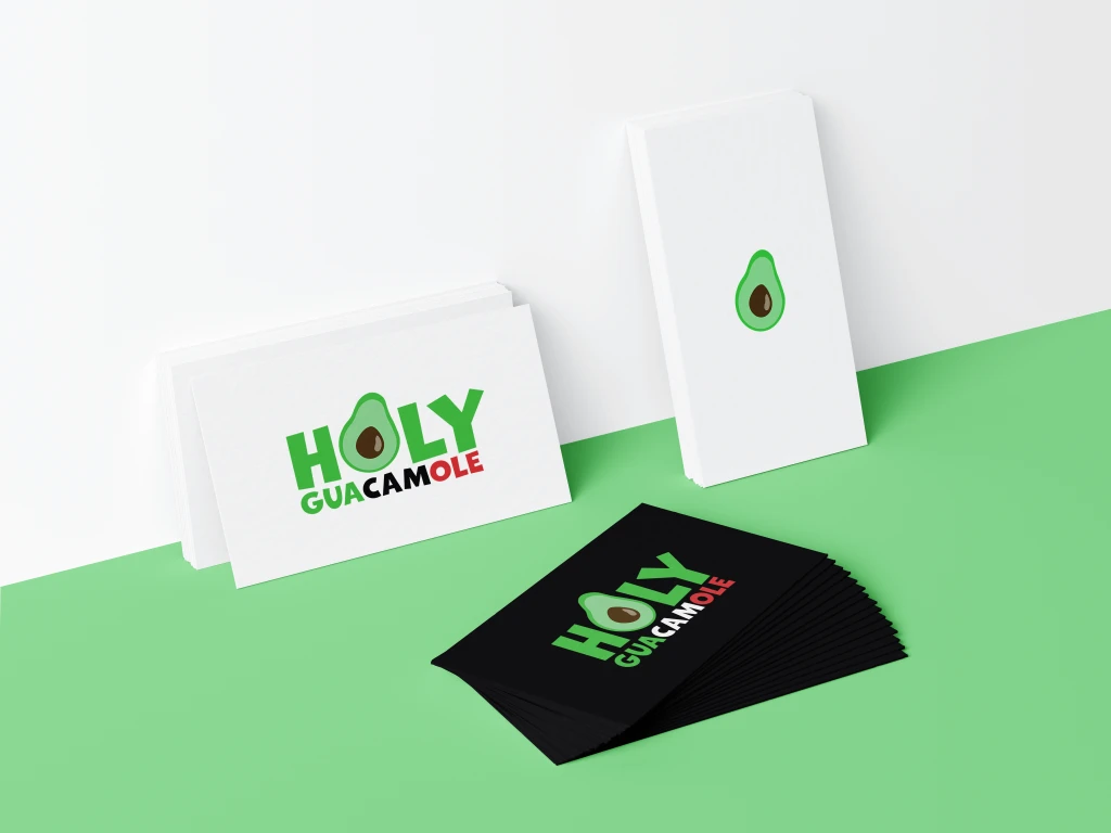 A product mockup featuring the Holy Guacamole's branding. Three sets of business cards placed on a light green surface against a white wall.