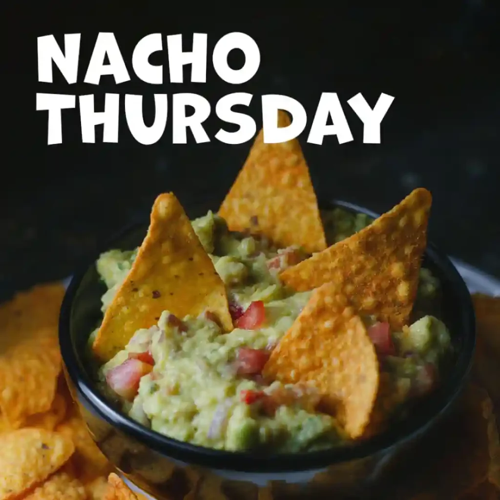 The Instagram post displaying a seasonal offer of Holy Guacamole, Nacho Thursday. In front of a black background, there is a small black bowl with guacamole and nachos dipped in it.